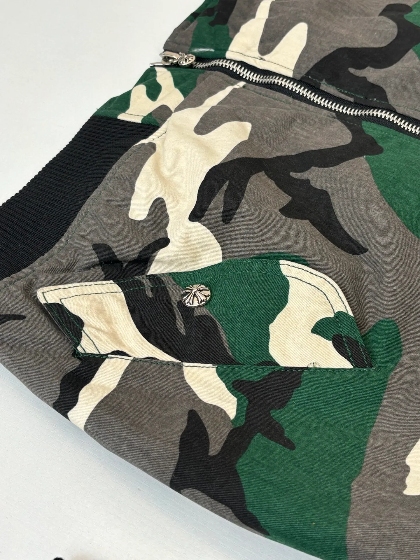 P1010 Chrome Heat*/CH Chrome Heat Camouflage Flight Jacket Cotton Jacket was purchased and developed by a Los Angeles agent for US$5,600. This model is made of custom-made military canvas fabric and is reproduced 1:1 according to the original model, with a piece of cloth printed camouflage pattern. The customization period for the chest sex pattern stamp is 20 days, the minimum order is 1800 pieces, and the color plate is matched. The hardware buckles are all made of electroplated 925 silver material, the weight is perfectly restored, and they are aged and oxidized to black. The back printing uses positioning screen glue printing, and the sleeve pockets are also positioned and opened by a template machine.  Size: M/L/XL/XXL
